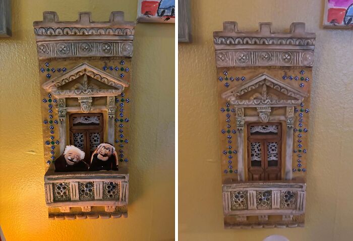 Decorative thrift store find showing a detailed miniature balcony with two puppet dolls on a yellow wall.