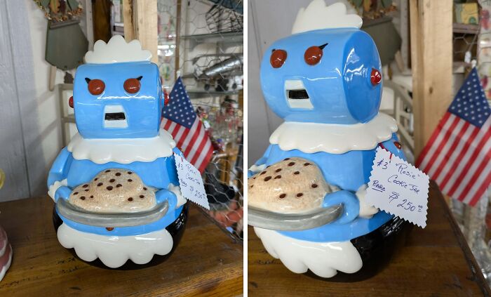 Blue vintage robot cookie jar thrift store find holding cookies with American flag in the background on wooden surface.