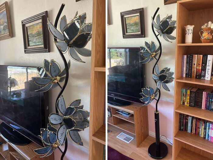 Decorative thrift store floor lamp with black and gold flower designs, standing beside a TV and wooden bookshelf.