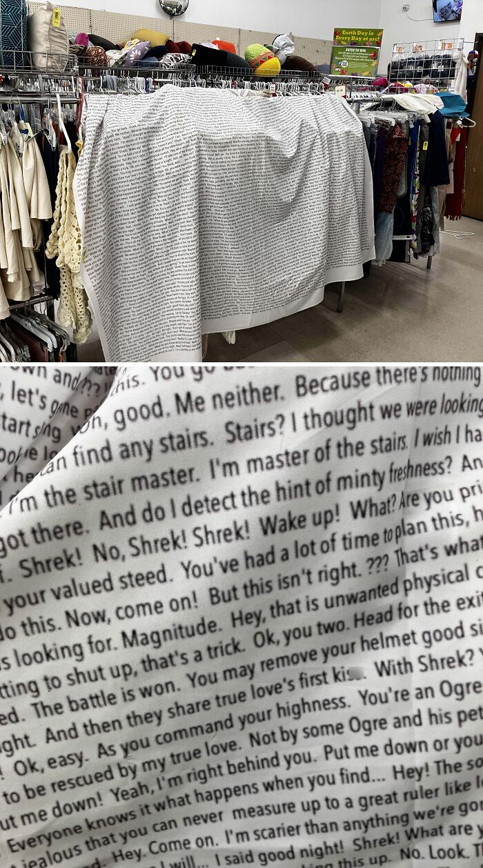 Thrift store fabric with printed text displayed among various clothing items and accessories on racks.