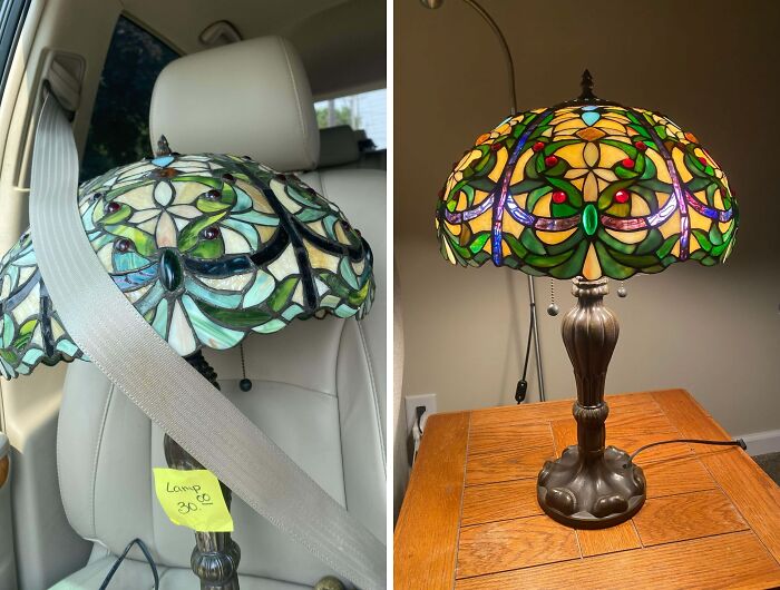 Stained glass thrift store lamp with intricate colorful floral design, shown secured in car and lit on wooden table.