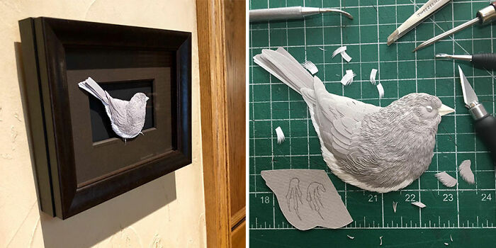 Paper wildlife sculpture of a bird with detailed feathers displayed in a black frame and crafted on a cutting mat.