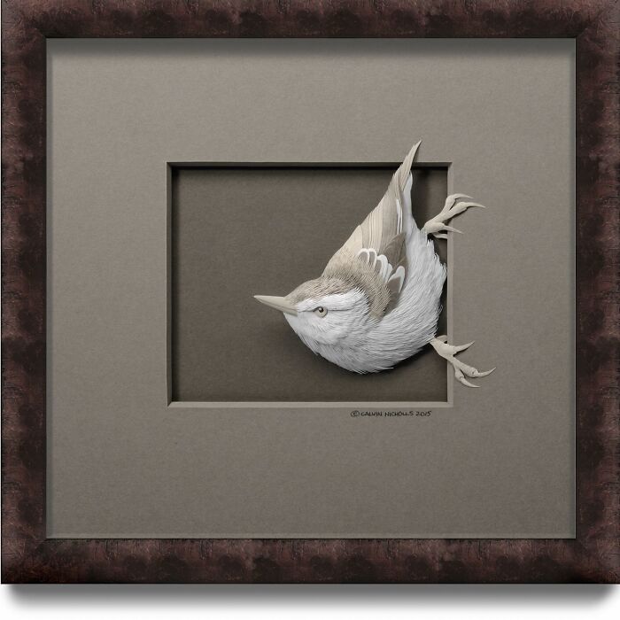 Paper wildlife sculpture of a bird appearing to emerge from the frame, showcasing stunningly realistic detail and texture.