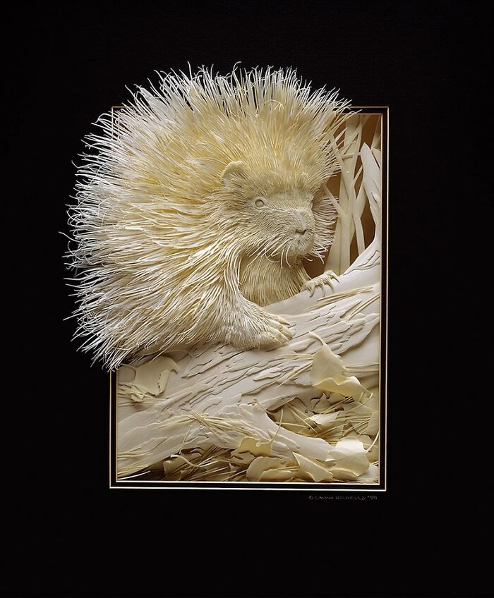 Intricately detailed wildlife sculpture of a porcupine crafted from layered paper by talented artist.