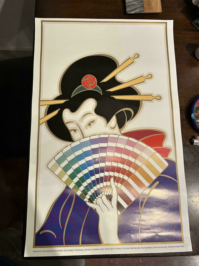 Colorful vintage artwork of a Japanese geisha holding a fan, a unique thrift store find displayed on a wooden surface.