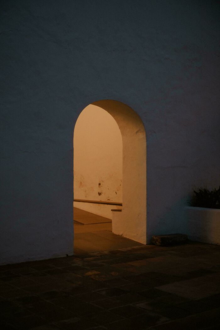 Archway glowing with warm light at night, captured in an accidental Renaissance photo with museum-quality composition.