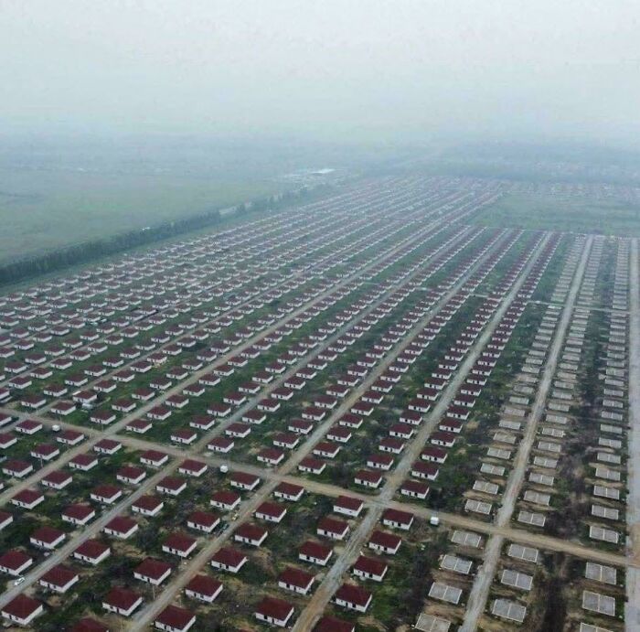 Aerial view of a $58 billion ghost city with rows of empty houses in an urban hell landscape.