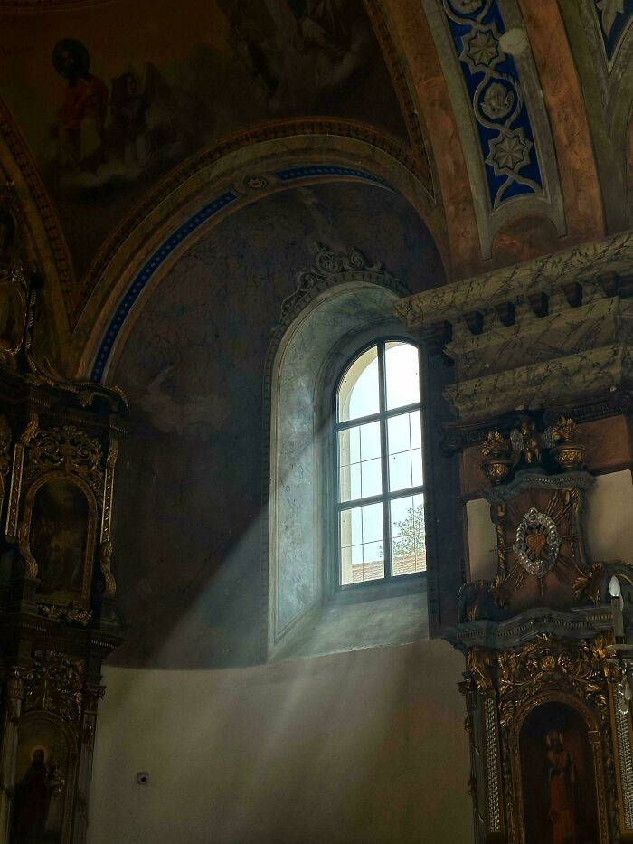 Sunlight streaming through a window in a historic chapel with detailed Renaissance-style architectural elements.
