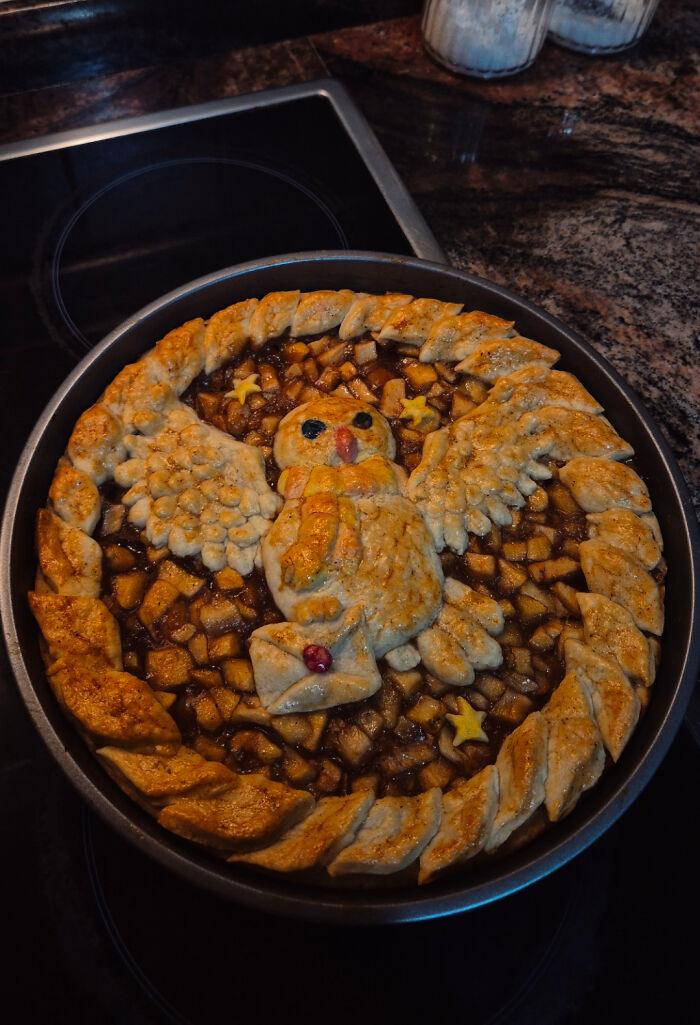 Decorative baked goods featuring a bird design made from pie crust on a fruit-filled pie, showcasing gorgeous baked goods artistry.