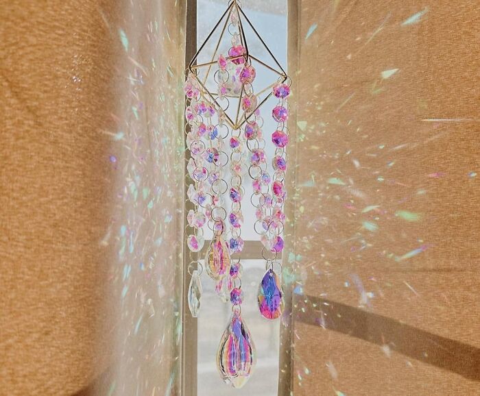 Colorful crystal decor hanging by window creating light reflections, a fun and functional home find.