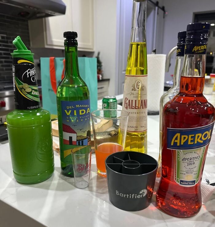 Various bottles and bar tools arranged on a kitchen counter showcasing fun and functional drink setups.