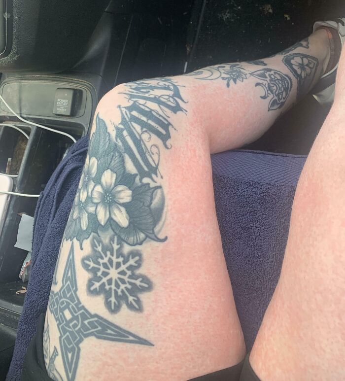 Close-up of a tattooed leg resting with visible extra finger highlighting unusual human body features.