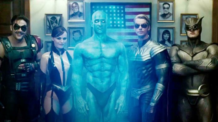 Group of superheroes posing in front of an American flag, representing bad movie details in confusing scenes.