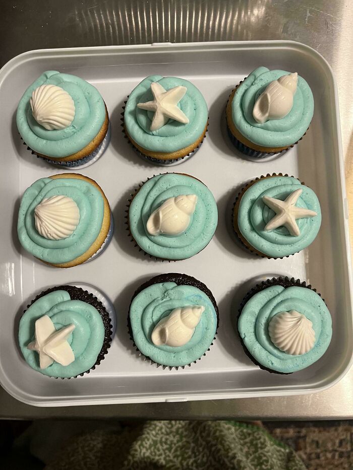 Cupcakes with blue frosting and seashell decorations, showcasing gorgeous baked goods with creative kitchen designs.