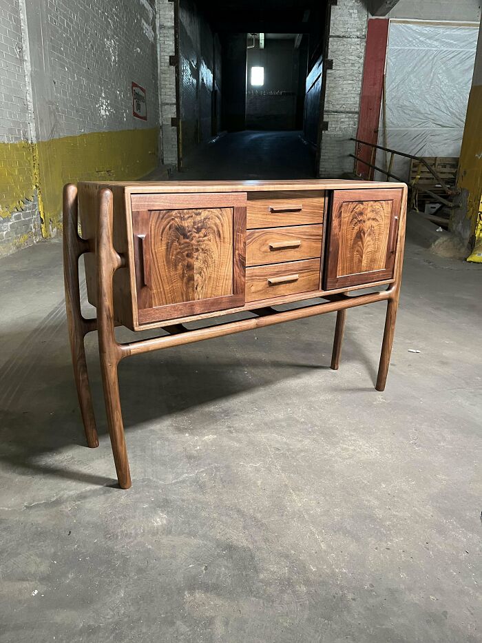 Handcrafted wooden sideboard with intricate grain patterns, showcasing woodworkers' incredible projects in a rustic industrial setting.