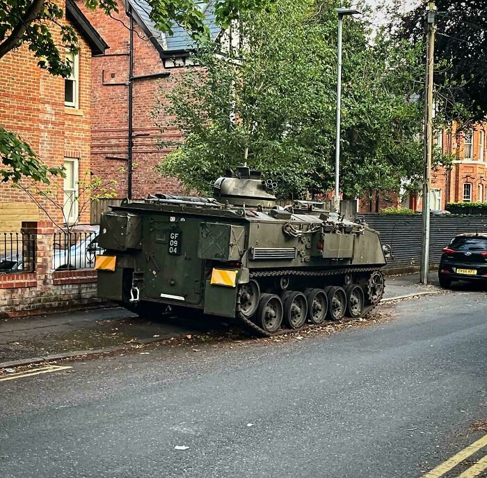 Military tank parked on a residential street, an unusual and striking example of parking fails shared online.