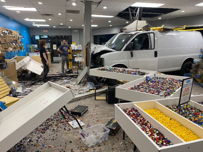 White van crashed inside a store causing major damage and scattered toys, illustrating a serious parking fail incident.