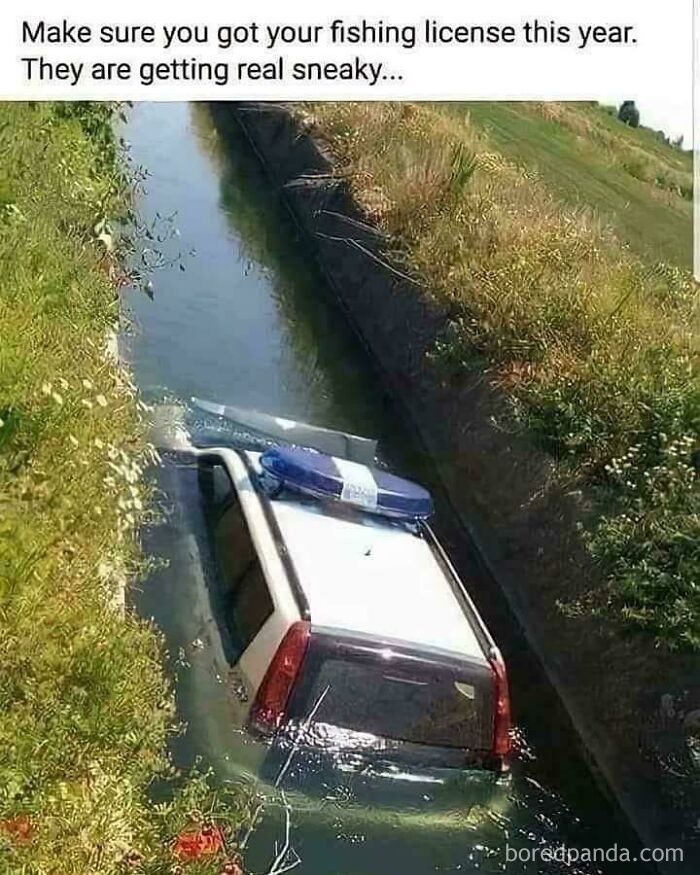 Police car partly submerged in a narrow ditch, highlighting an extreme parking fail shared online.
