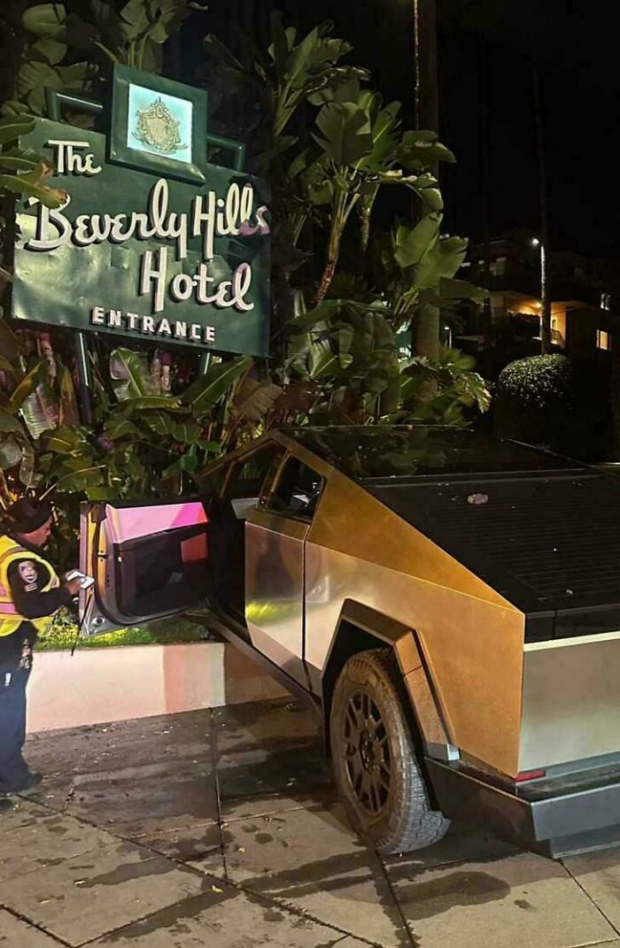 Police officer writing ticket for Tesla Cybertruck parked incorrectly near Beverly Hills Hotel entrance at night, a notable parking fail.