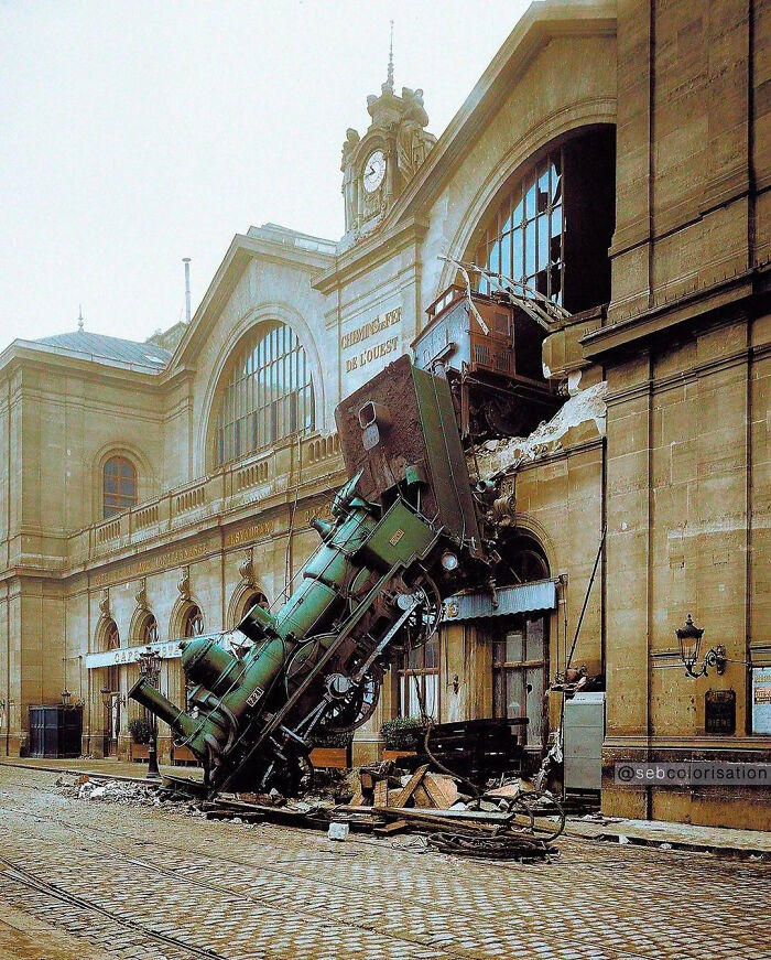 Train crashed through building wall, a major parking fail captured outside a historic station on cobblestone street.