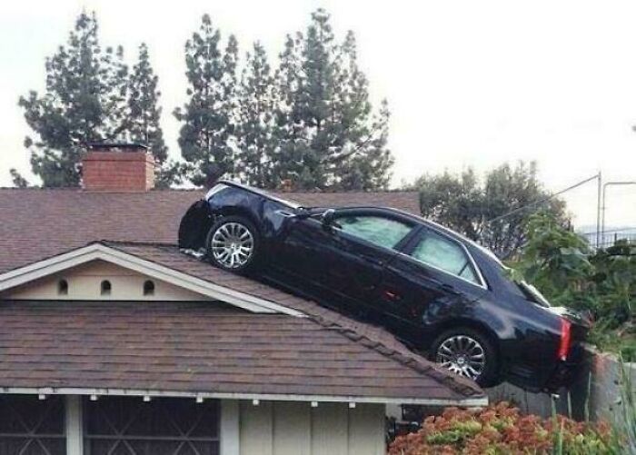 Black car parked on a steep rooftop, illustrating one of the most unusual and surprising parking fails captured online.