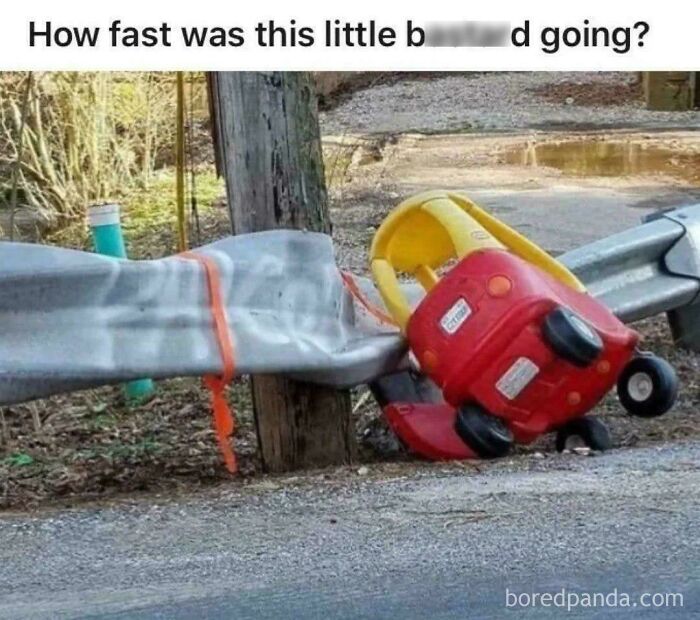 Toy car crashed and stuck against a bent guardrail on roadside, illustrating a humorous parking fail moment.