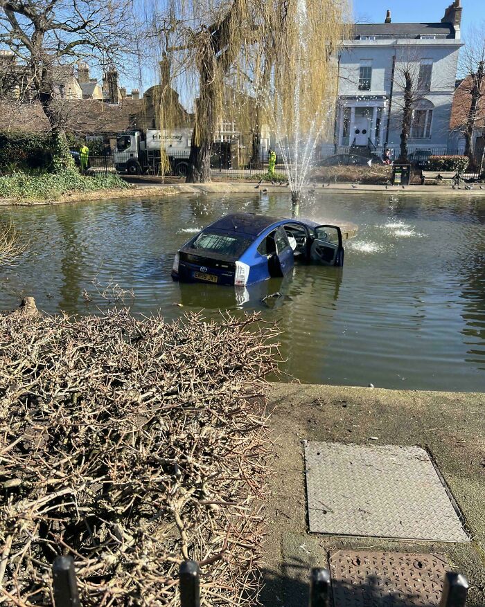 Blue car submerged in a pond with open doors, one of many parking fails shared online.
