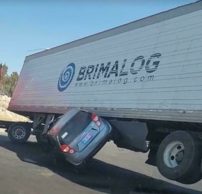 Car crushed under a large truck in a severe parking fail, illustrating one of the worst parking fails shared online.