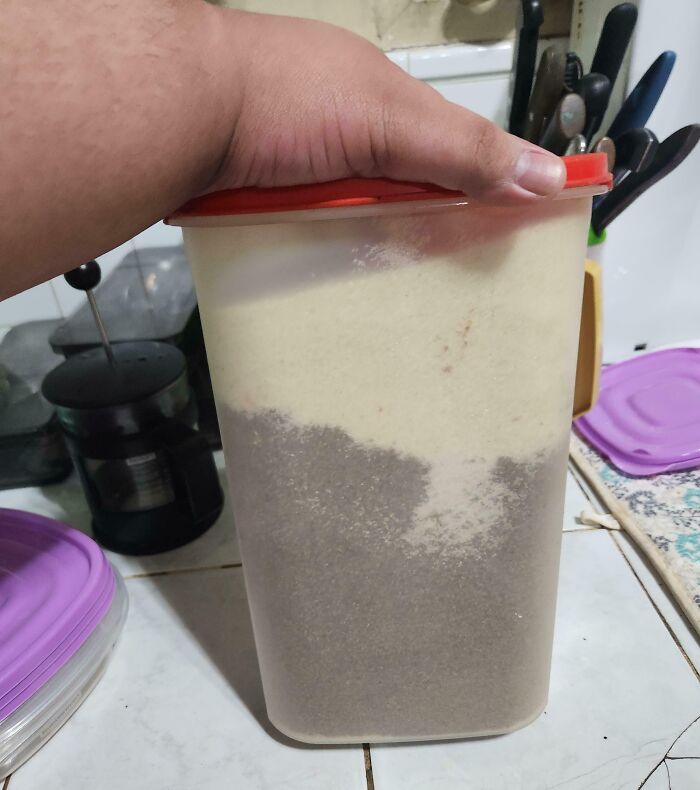 Mano sosteniendo un recipiente con polvo, ejemplificando la actitud de un hermano con sentimientos de privilegio.