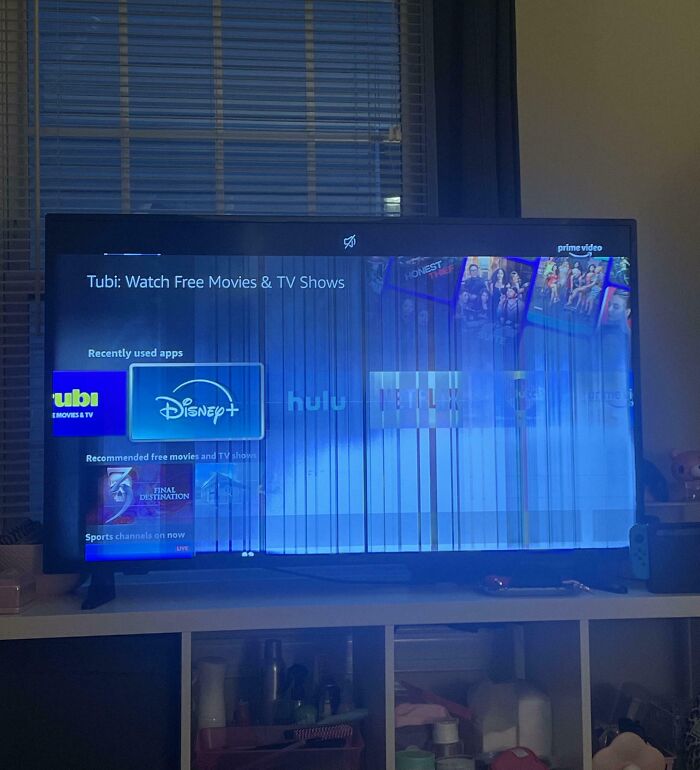 Televisor con pantalla dañada mostrando aplicaciones de streaming, reflejando el impacto de tener un hermano con derecho.