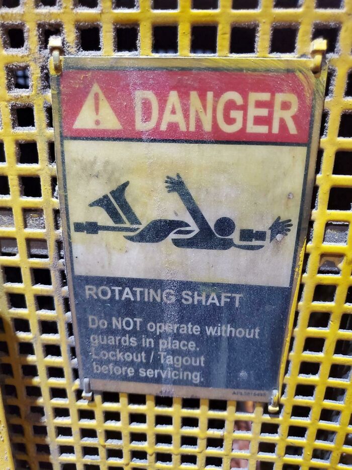 Warning sign showing danger of rotating shaft with a graphic, capturing a creepy and unsettling moment of hazard caution.