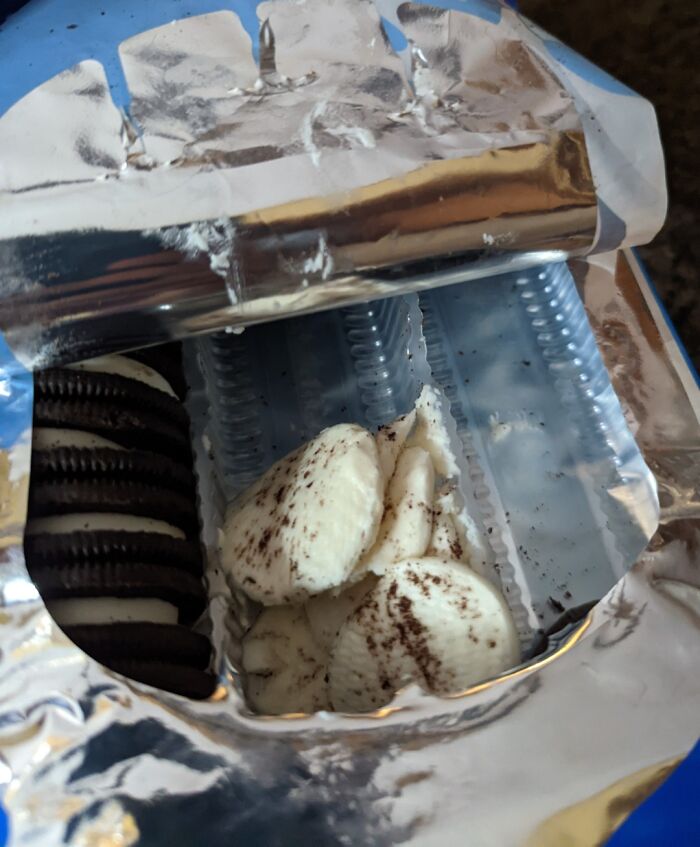 Partially eaten cookies inside an open package, showing separated cookie cream and biscuits in a sibling shenanigans scene.
