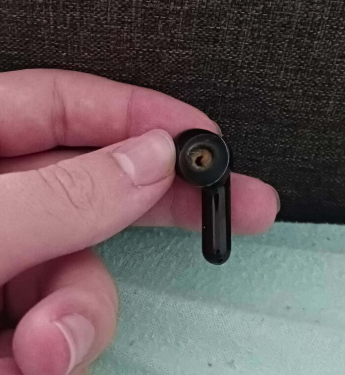 Mano sosteniendo audífono dañado que ilustra situaciones comunes con un hermano con sentido de derecho.