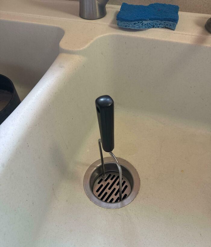 Utensilio de cocina encajado en el desagüe del fregadero, mostrando un ejemplo de hermano con actitud de derecho.