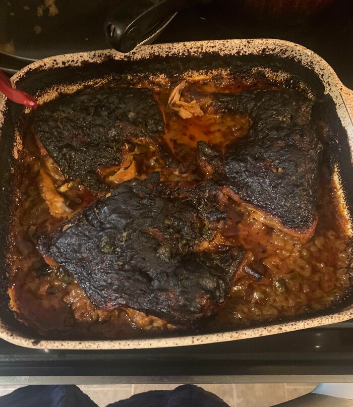 Burnt food in a baking dish, showing a cooking fail that fits with sibling shenanigans and kitchen mishaps.