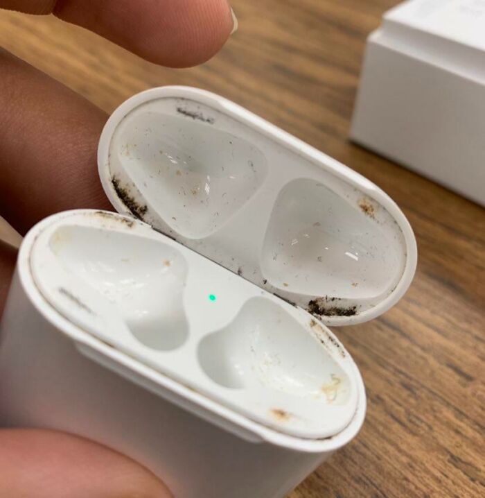 Dirty AirPods case held open showing dirt and debris inside, illustrating sibling shenanigans and mischief moments.