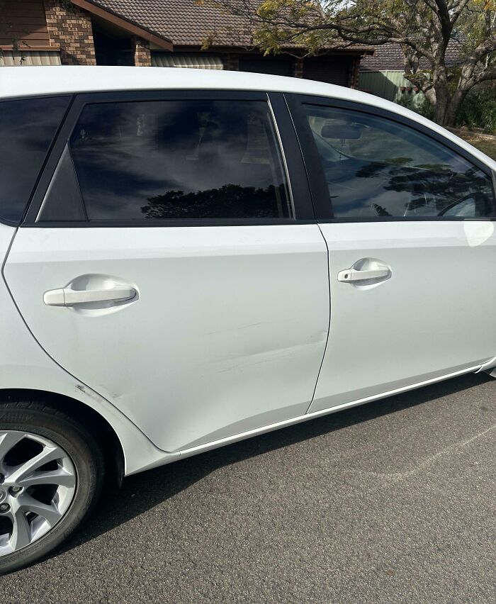 Raspón en la puerta de un coche blanco que muestra lo que es tener un hermano con actitud de derecho.