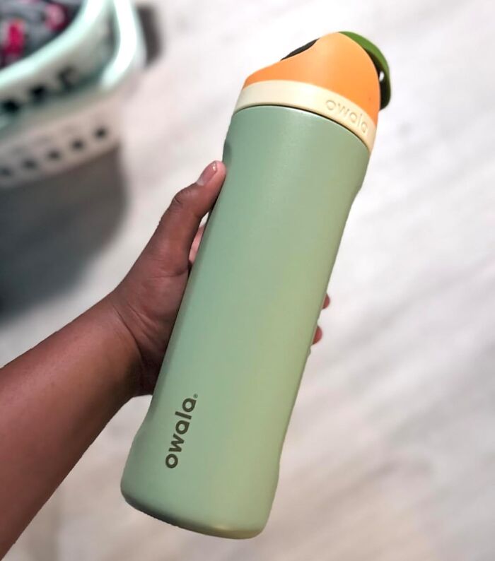 Hand holding a green and orange Owala water bottle featured in Amazon best seller list worth the hype products.