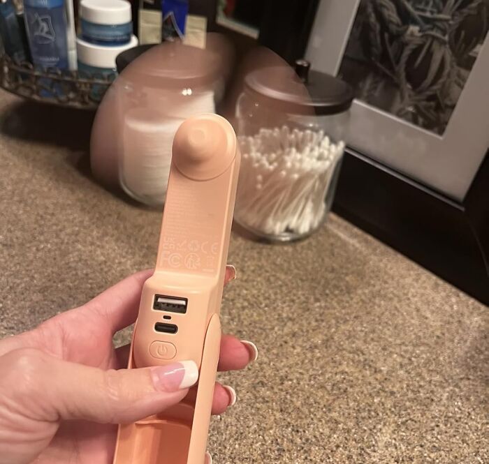 Hand holding a portable USB charging handheld fan, one of Amazon best seller list items worth the hype.