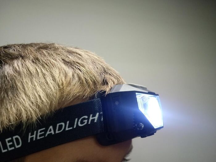 Person wearing an LED headlight, demonstrating one of Amazon best seller list products worth the hype for hands-free lighting.
