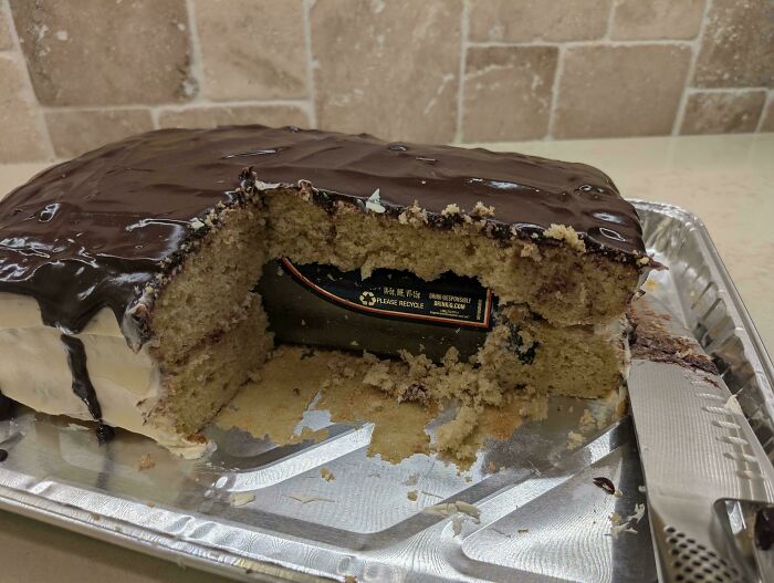 Partially eaten cake with a hidden beer can inside, showcasing a witty surprise for those too clever for their own good.