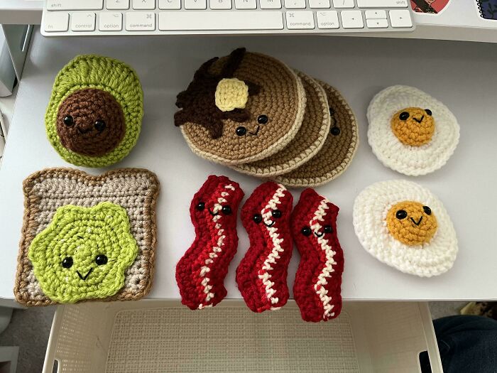 Crocheted avocado, toast, bacon, pancakes, and eggs with cute faces, showcasing creative crocheting projects.