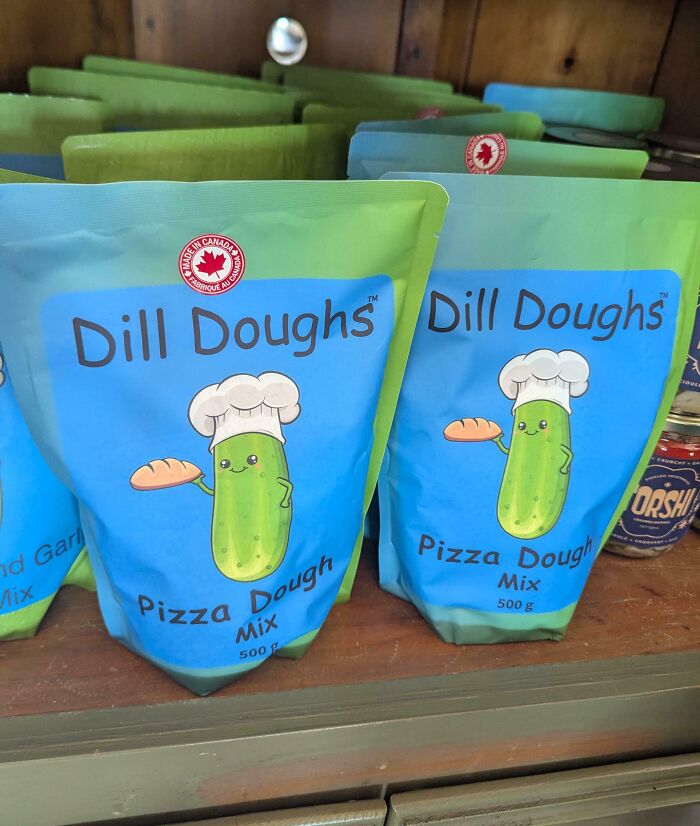 Packages of Dill Doughs pizza dough mix with a playful pickle chef illustration, showcasing witty product branding.