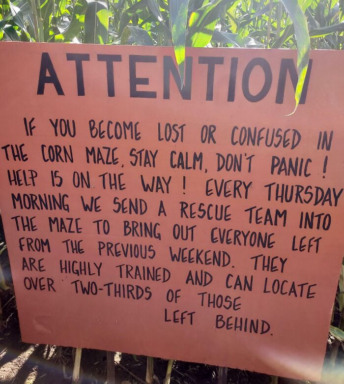 Sign in a corn maze with a witty message about rescue teams helping those lost, showcasing people being too witty for their own good.