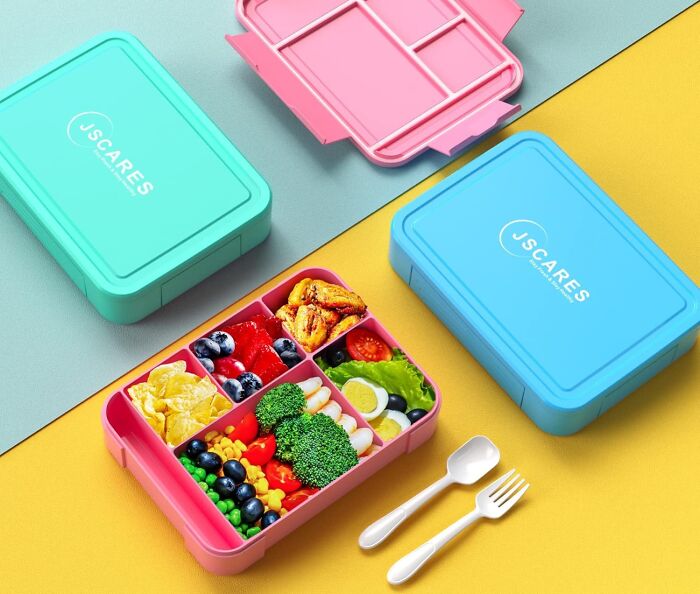 Colorful back to school lunch boxes filled with healthy snacks and utensils ready for a nutritious school meal.