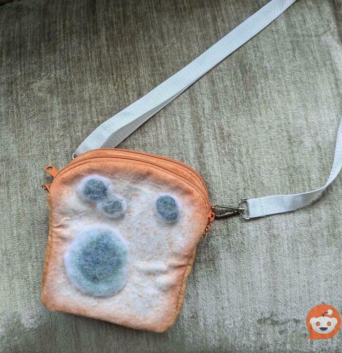 Crossbody bag designed to look like a moldy slice of bread, a funny example of awful taste but great e*******n.