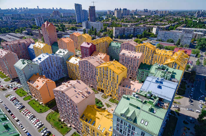 Aerial view of colorful urban apartment buildings in a densely packed cityscape highlighting urban hell issues.