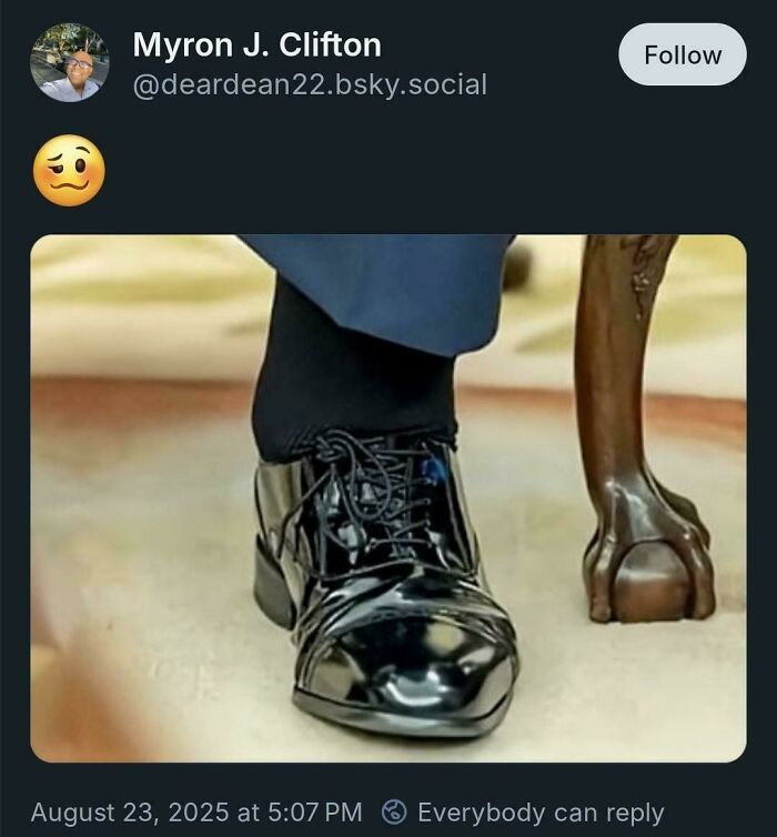 Close-up of a shiny black dress shoe with a bent toe next to an oddly shaped wooden table leg showing an attempt gone wrong.