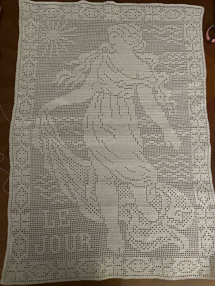 Intricate crocheted piece featuring a dancing woman and floral patterns, showcasing advanced crocheting skill and artistry.