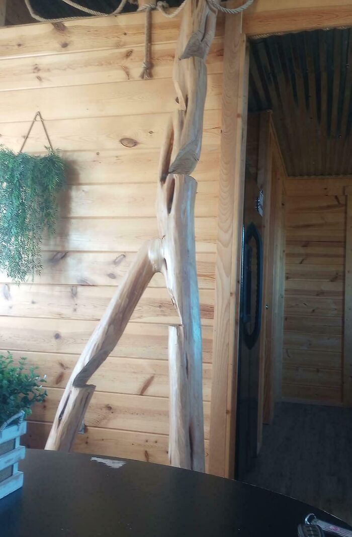 Wooden handrail with poor DIY craftsmanship in a rustic interior, showcasing one of the DIY disasters from a museum of mistakes.